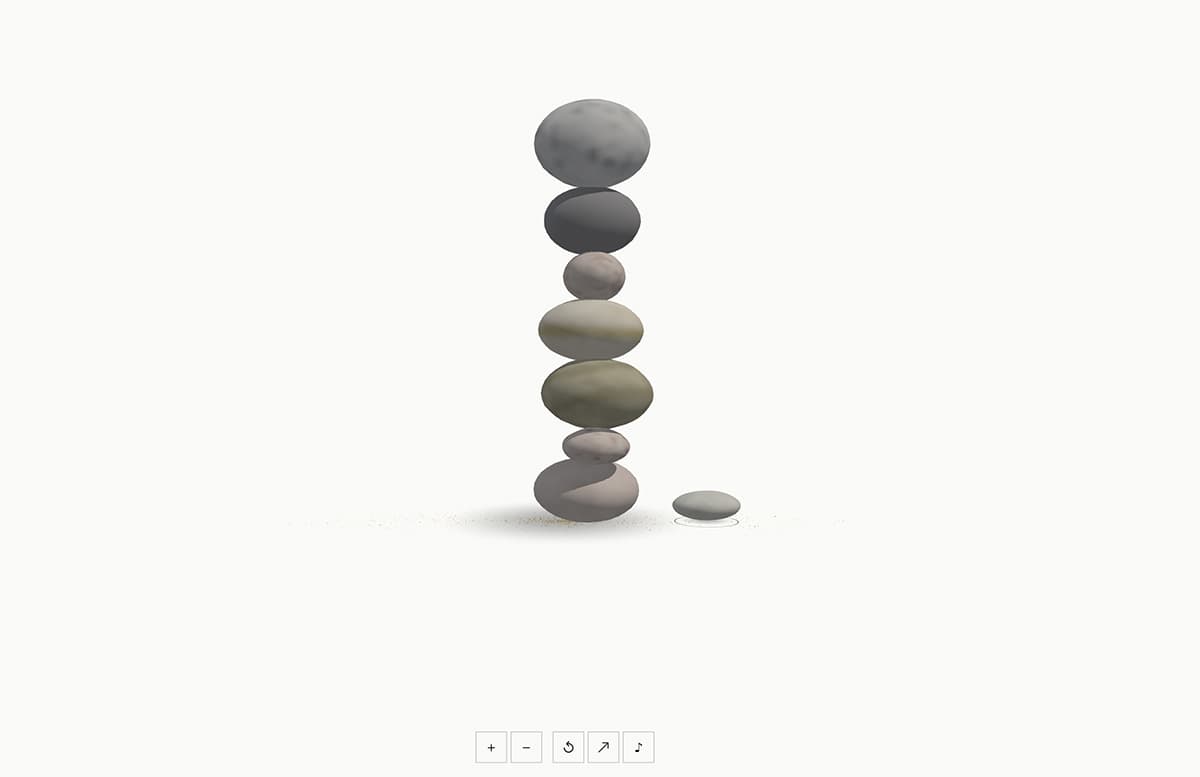A cairn of pale stones balanced on a soft white ground
